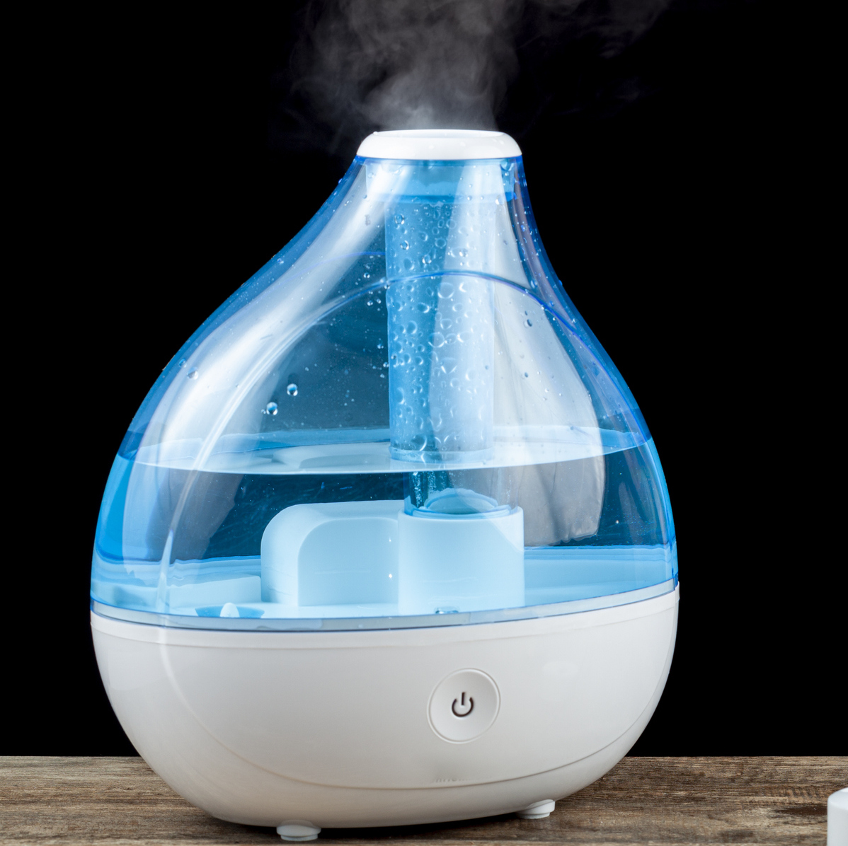 Asthma, allergy attack concept with ultrasonic air humidifier creating cool mist and a woman holding an inhaler to administer bronchodilator