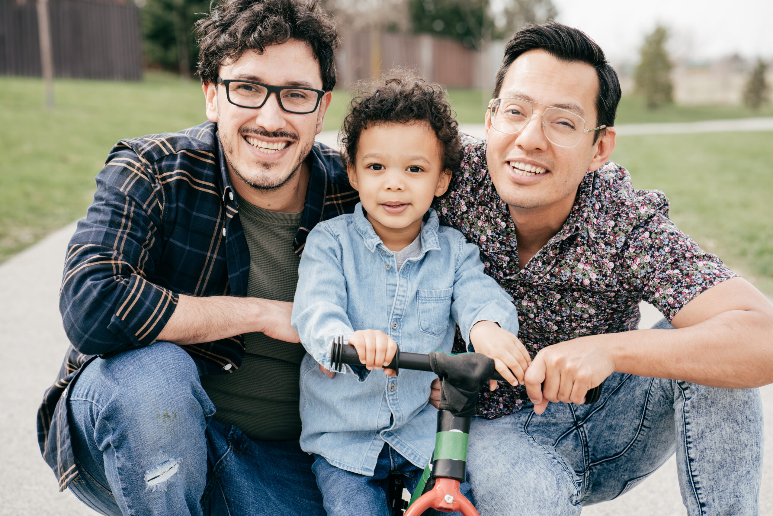 Happy family with two dads and toddler son