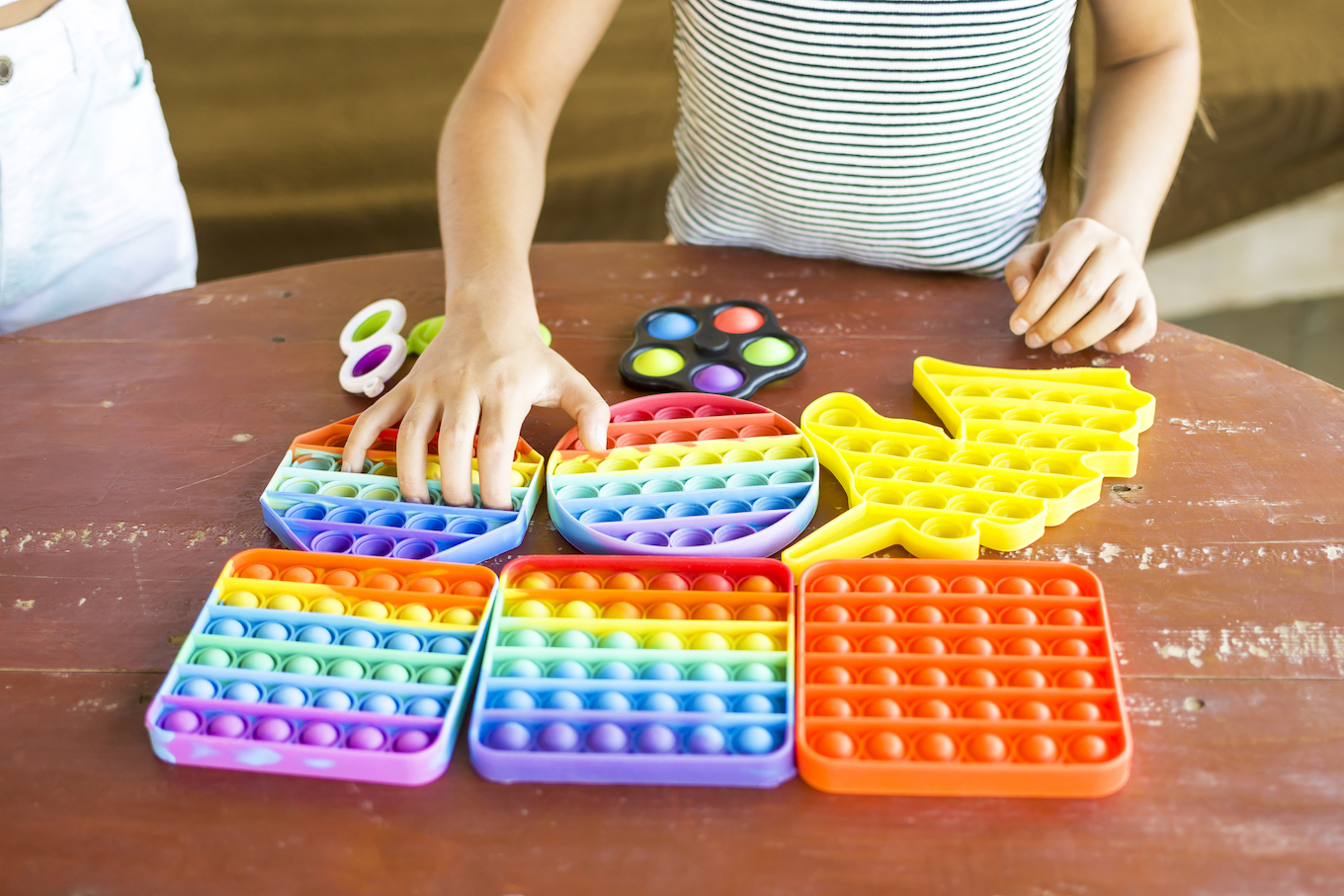 Beautiful girls enjoying antistress rainbow pop it fidget