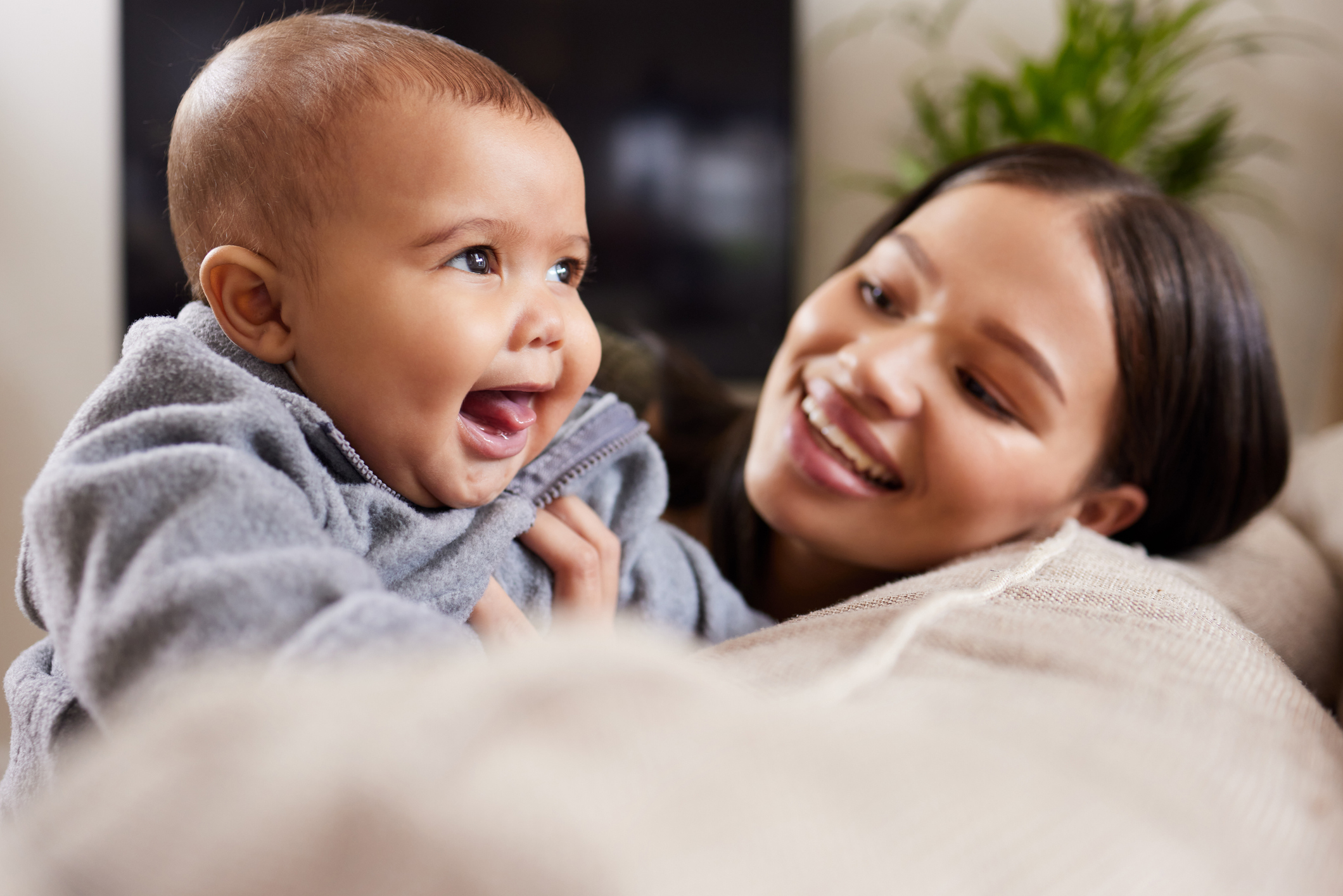 Shot of a young woman relaxing with her adorable baby on the sofa at home