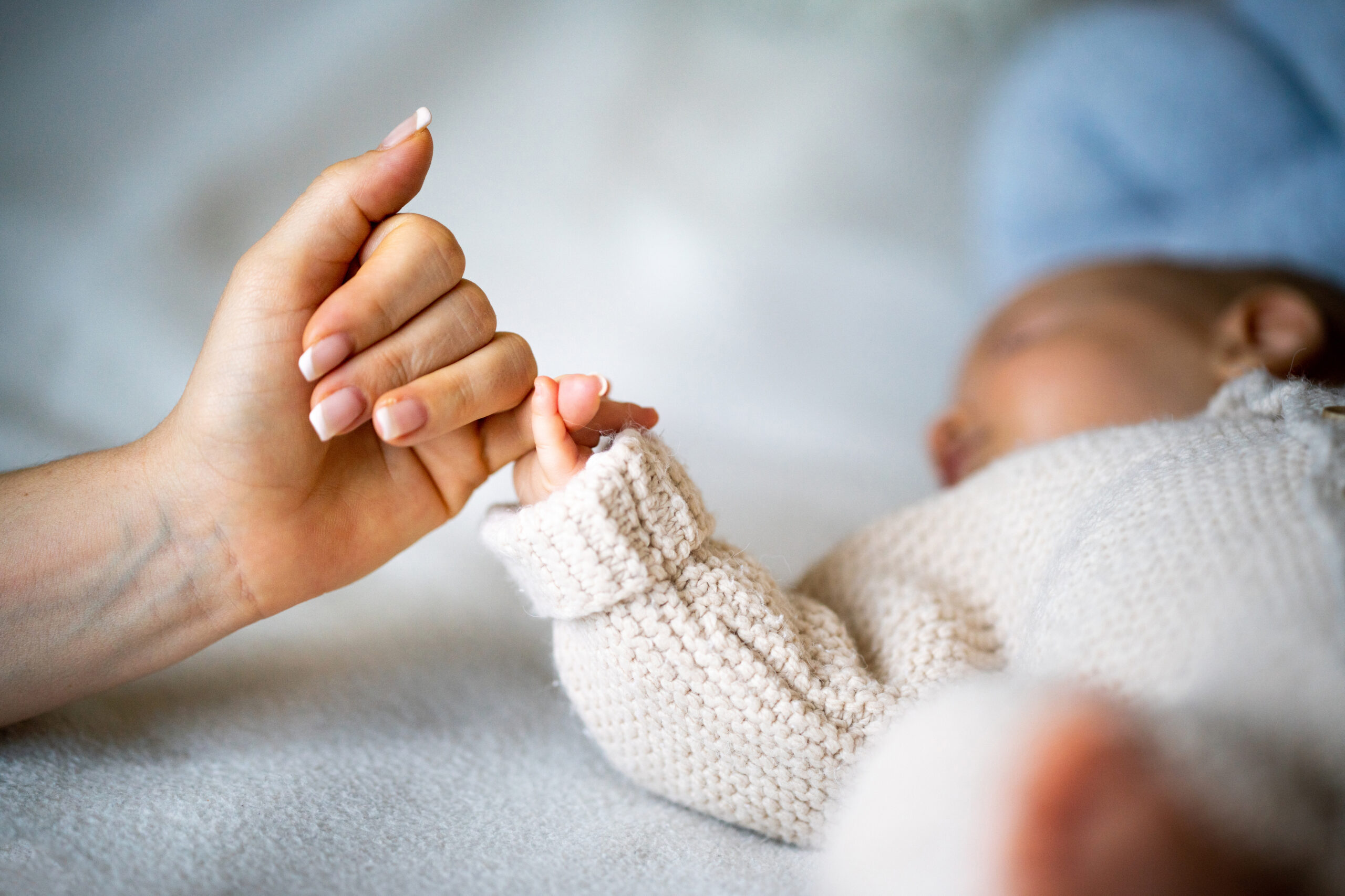 Hand holding newborn baby's hand