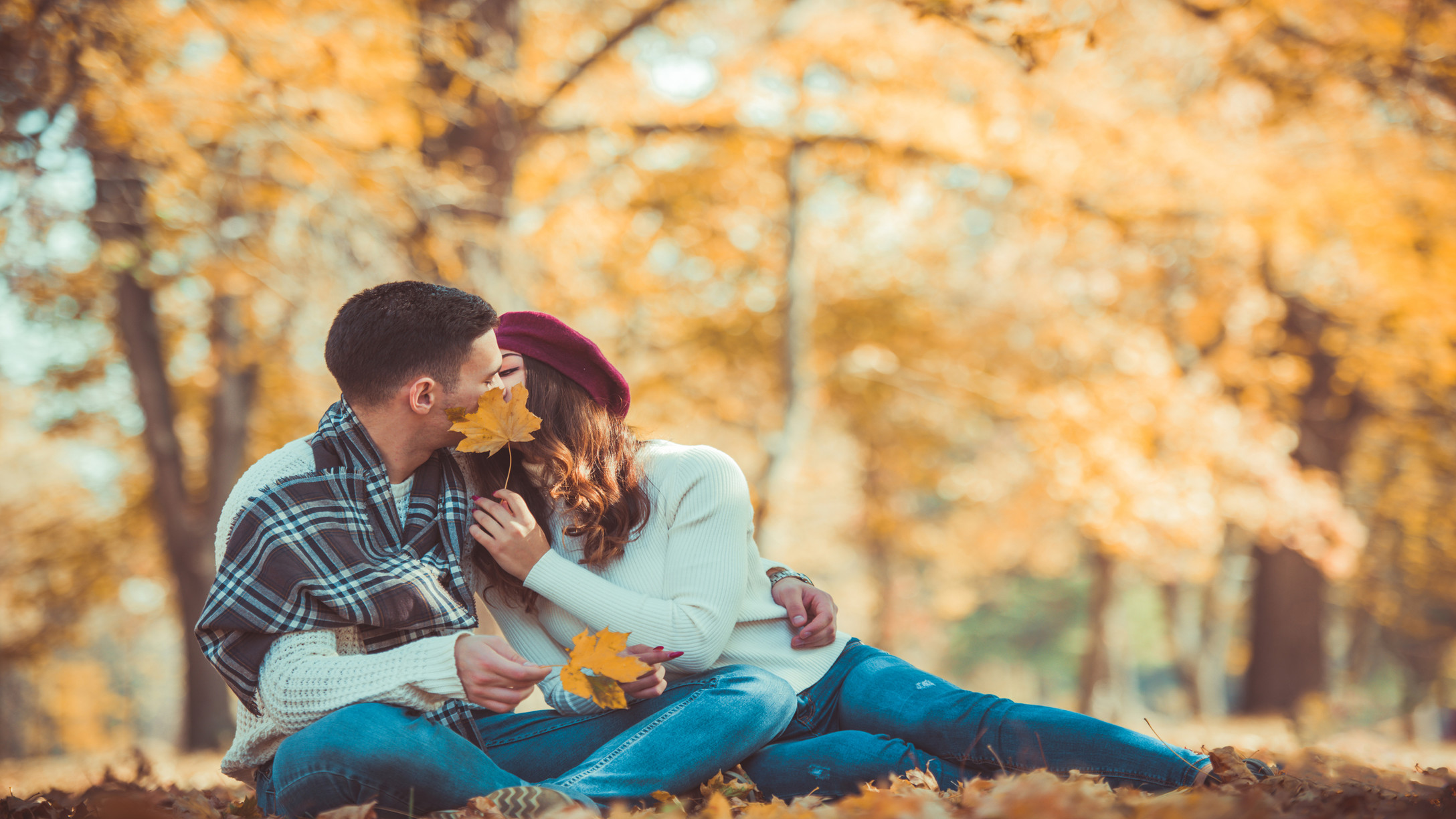 couple kissing in the fall leaves