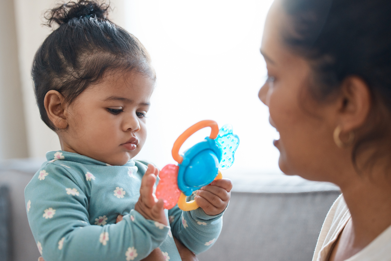 Shot of an adorable little girl playing with a toy while bonding with her mother