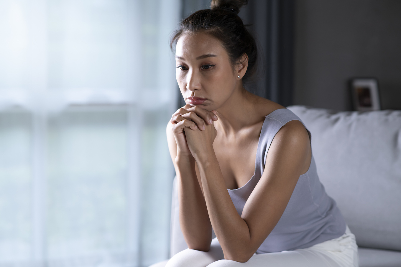 Woman feeling sad tired and worried suffering depression in mental health.