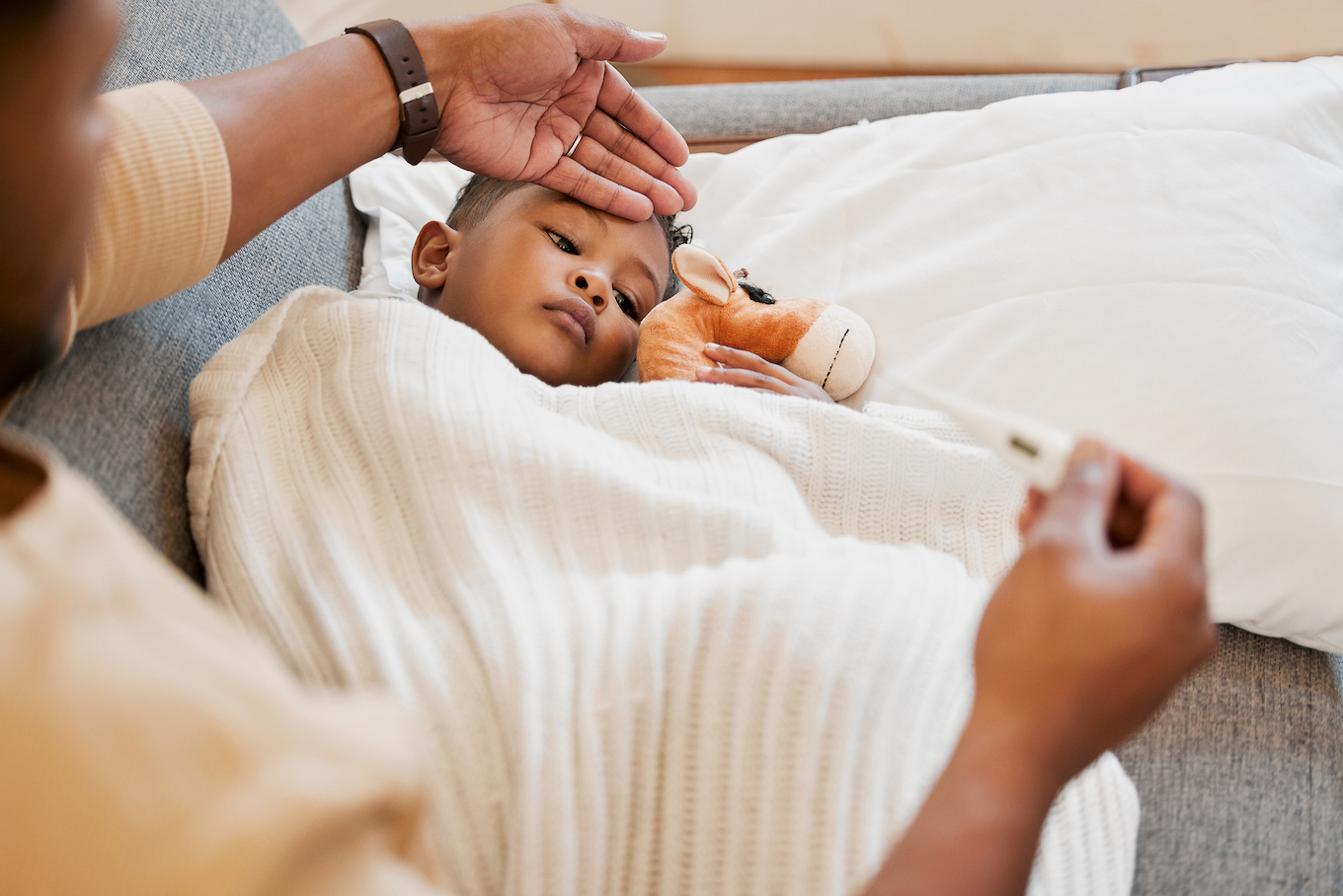 Sick, flu and cold child in bed, sad and ill with allergy and unwell at home with his worried mother.