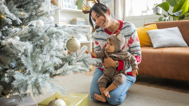 mom and child in front of decorated Christmas tree
