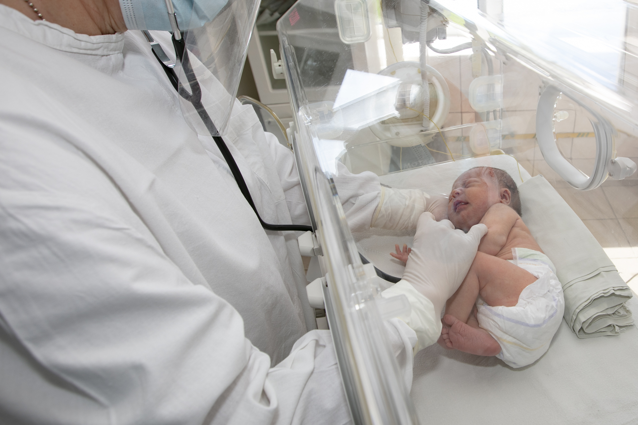 A doctor watches over a premature baby in the hospital.