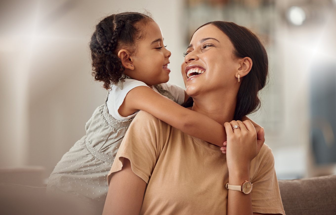 Happy mama with girl child, hug in home and weekend play time lifestyle for mom parent. Funny crazy kid in living room, mother holding toddler with smile and love bonding together on mothers day