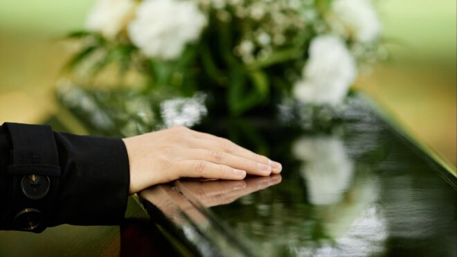 Hand on coffin