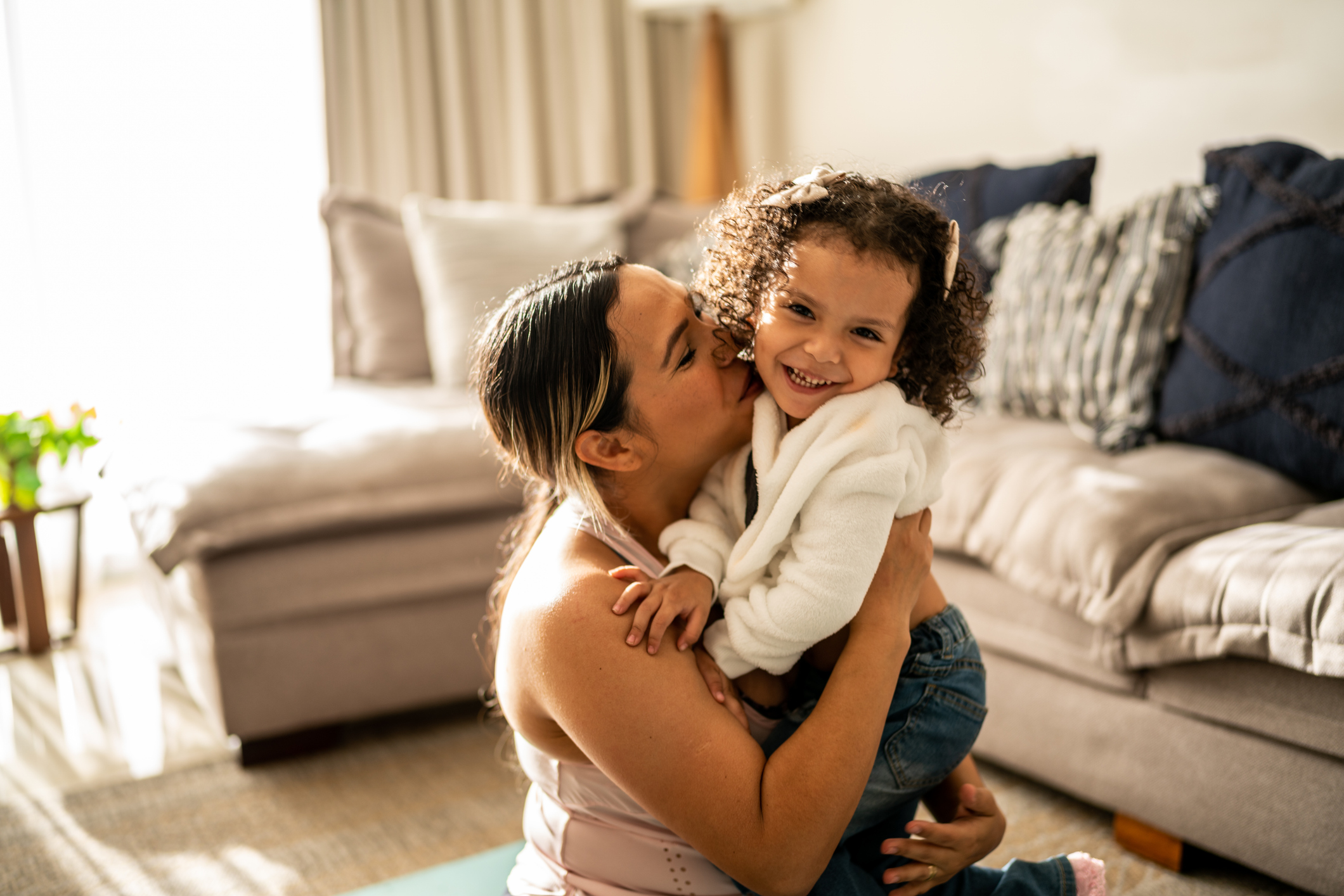 Portrait of toddler girl having fun with her mother in the living room at home