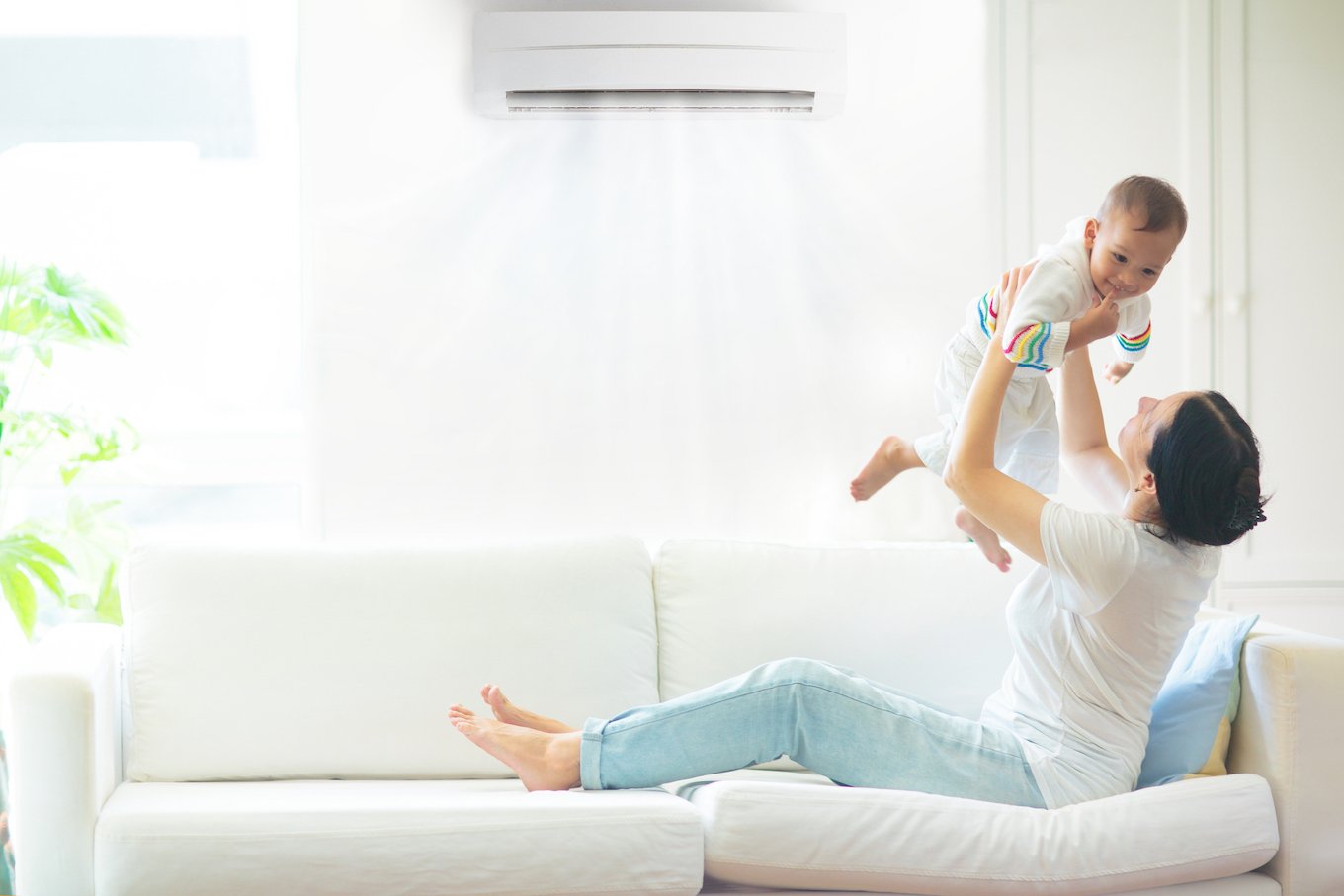 Mother and child with air conditioner remote