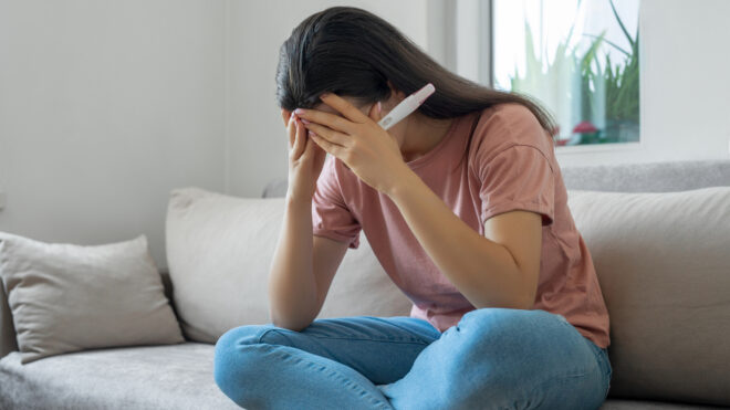Disappointed woman holding a pregnancy test