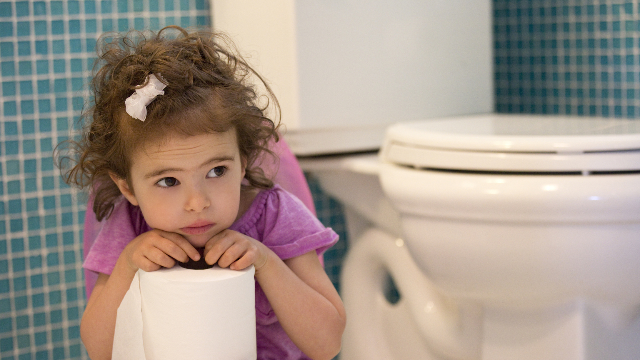 Girl holding toilet paper in the bathroom