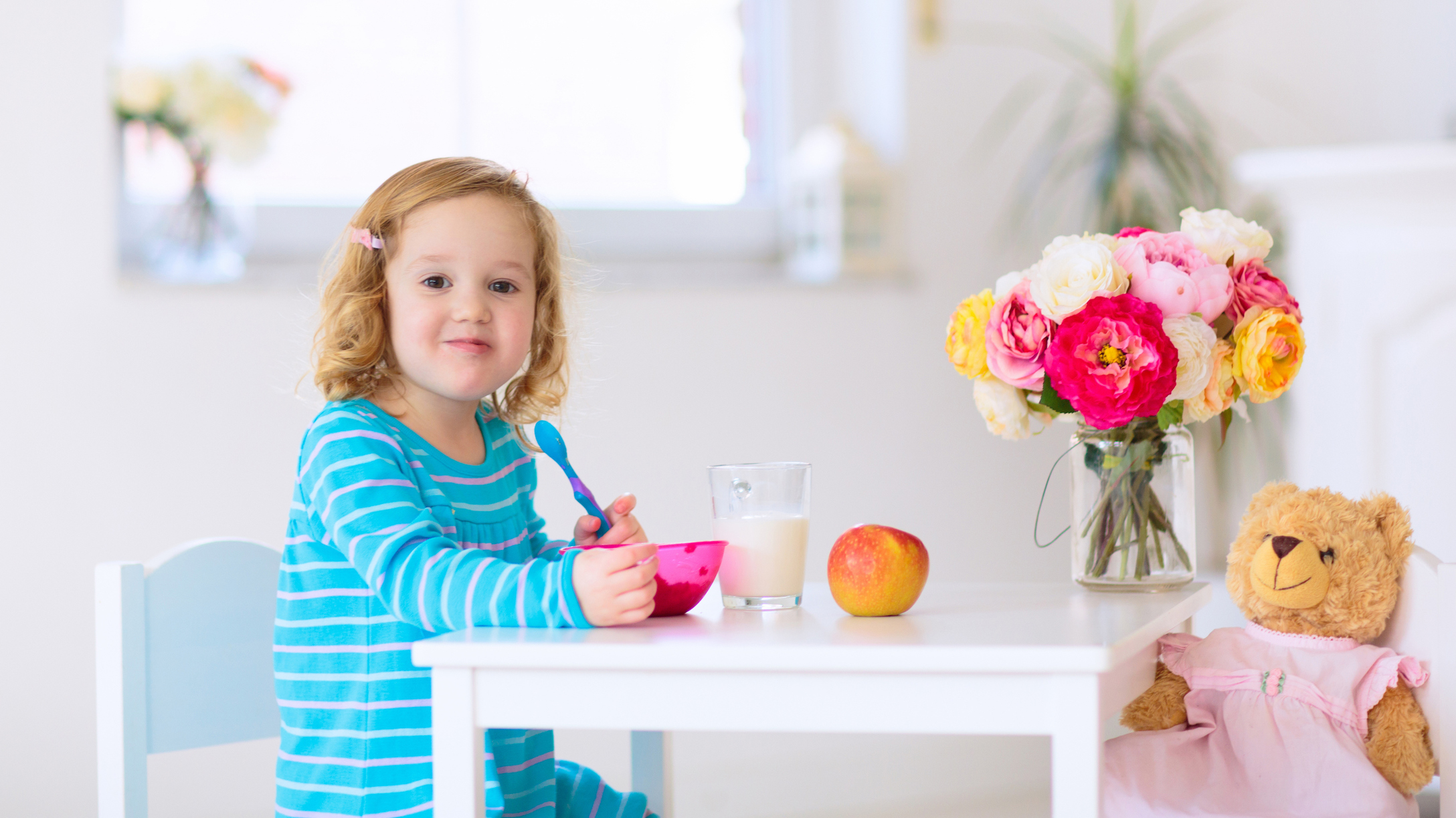 Girl sitting at a table eating breakfast