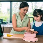 mom packing lunch for daughter