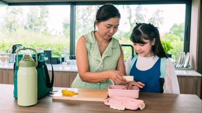 mom packing lunch for daughter
