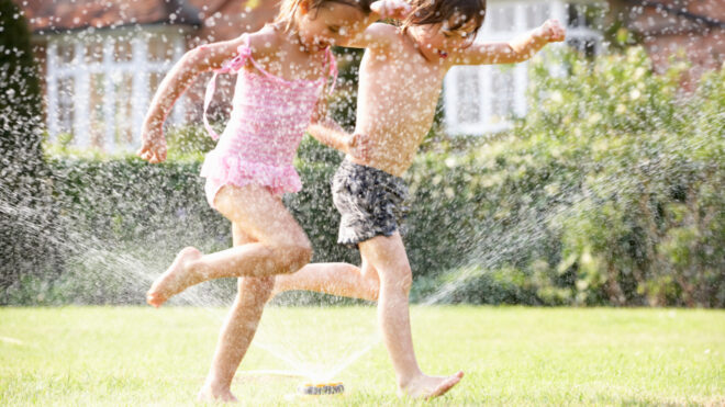 kids running through sprinkler