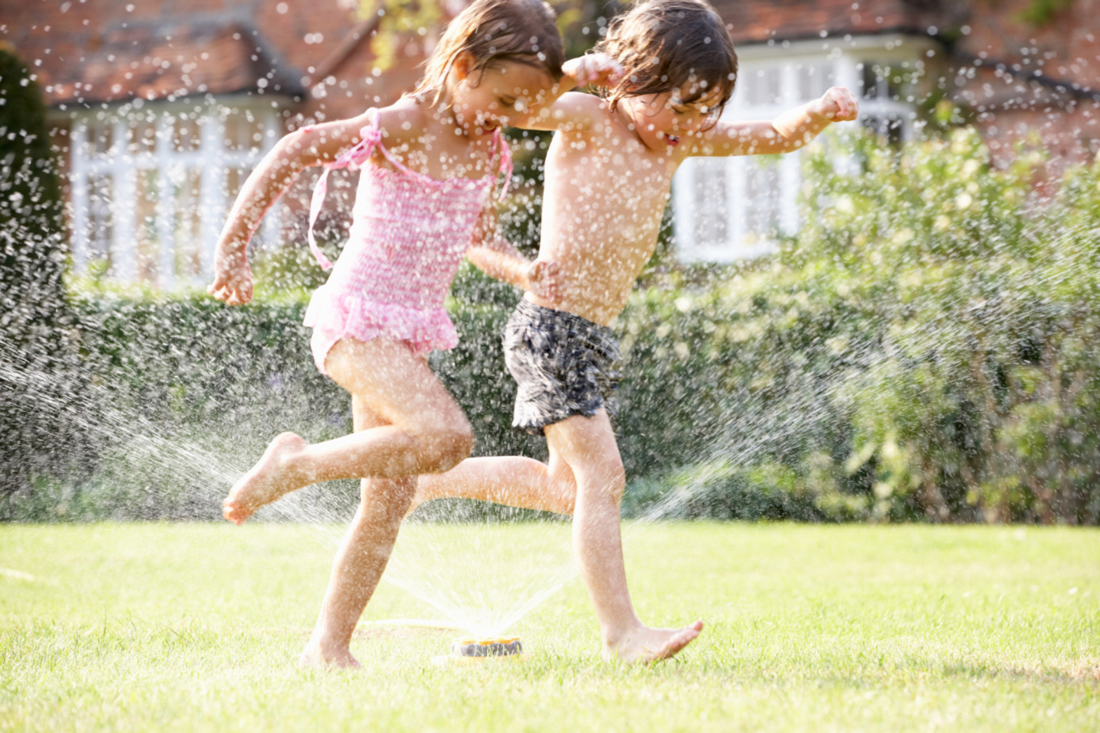 kids running through sprinkler