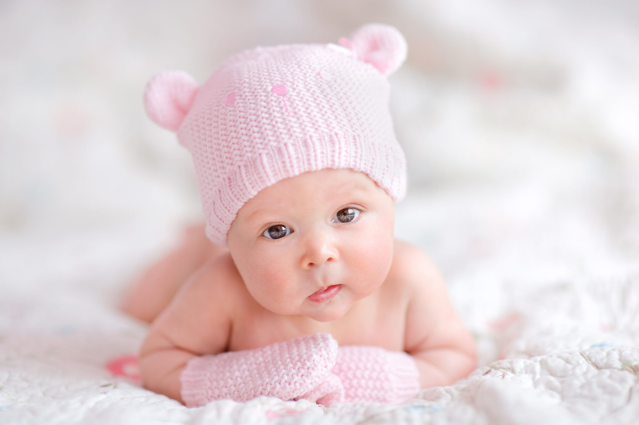 newborn baby girl in pink knitted bear hat
