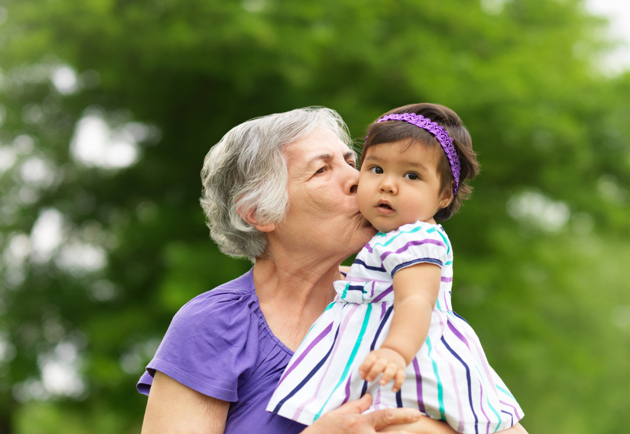 grandmother kissing granddaughter