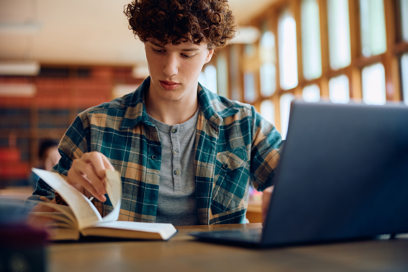 Male student learning at high school library.