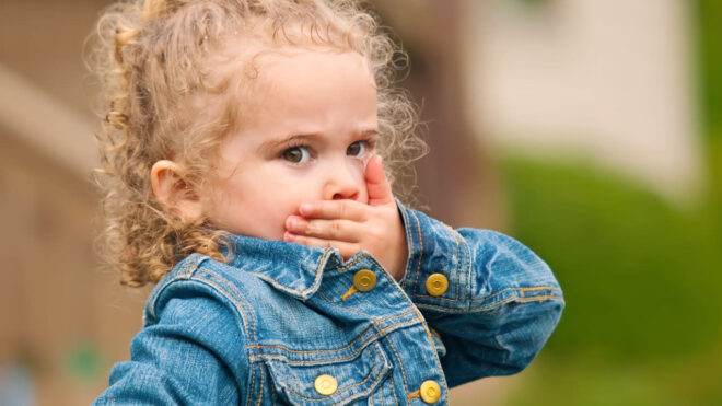 Girl covering her mouth with her hand.