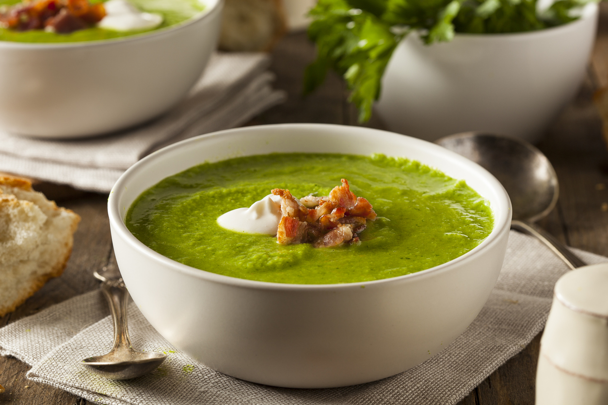 Homemade green spring pea soup in a white bowl