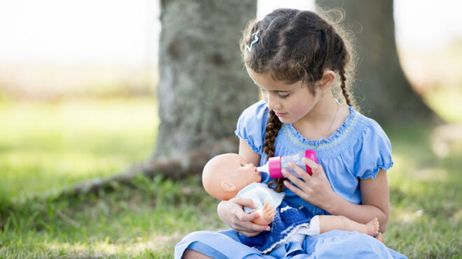 Little girl playing with baby doll