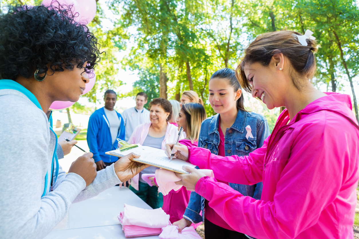 Diverse people registering for charity breast cancer awareness race