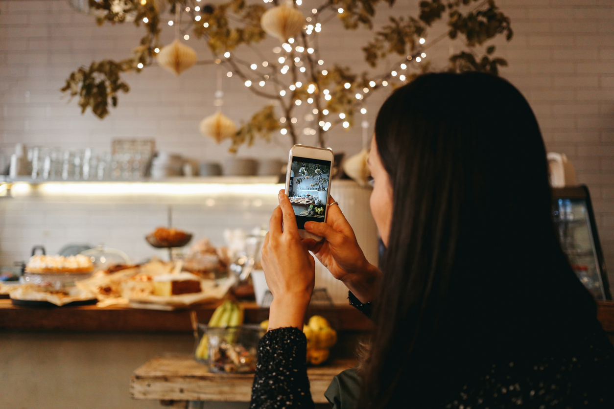 Young brunette taking a photo with a smartphone