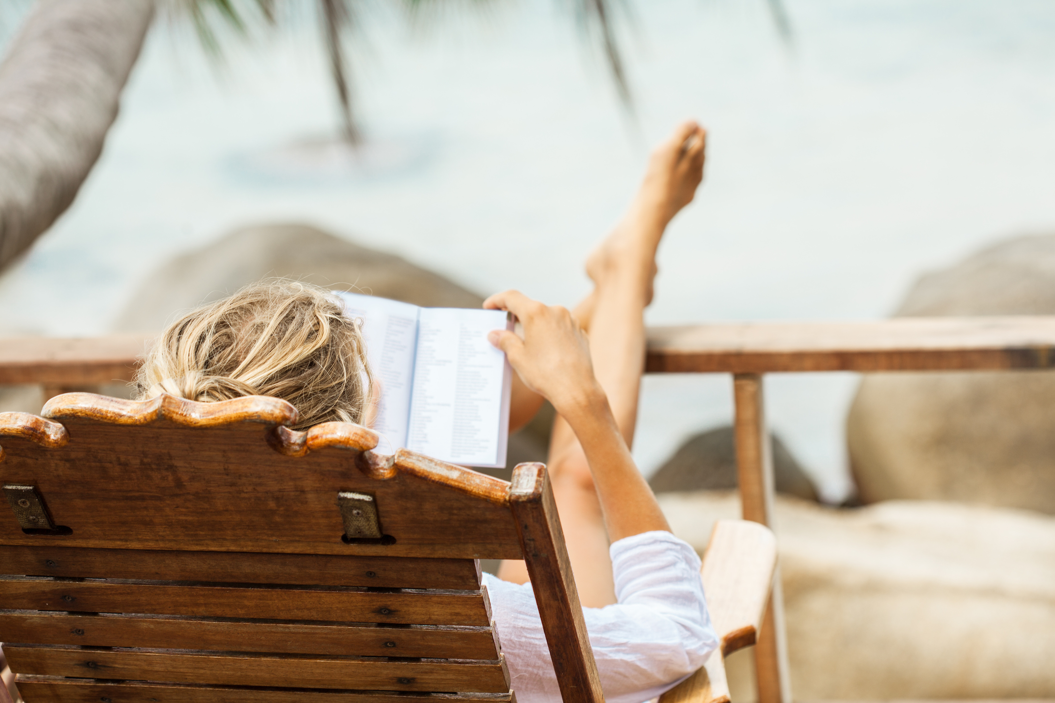 woman reading a book on the beach