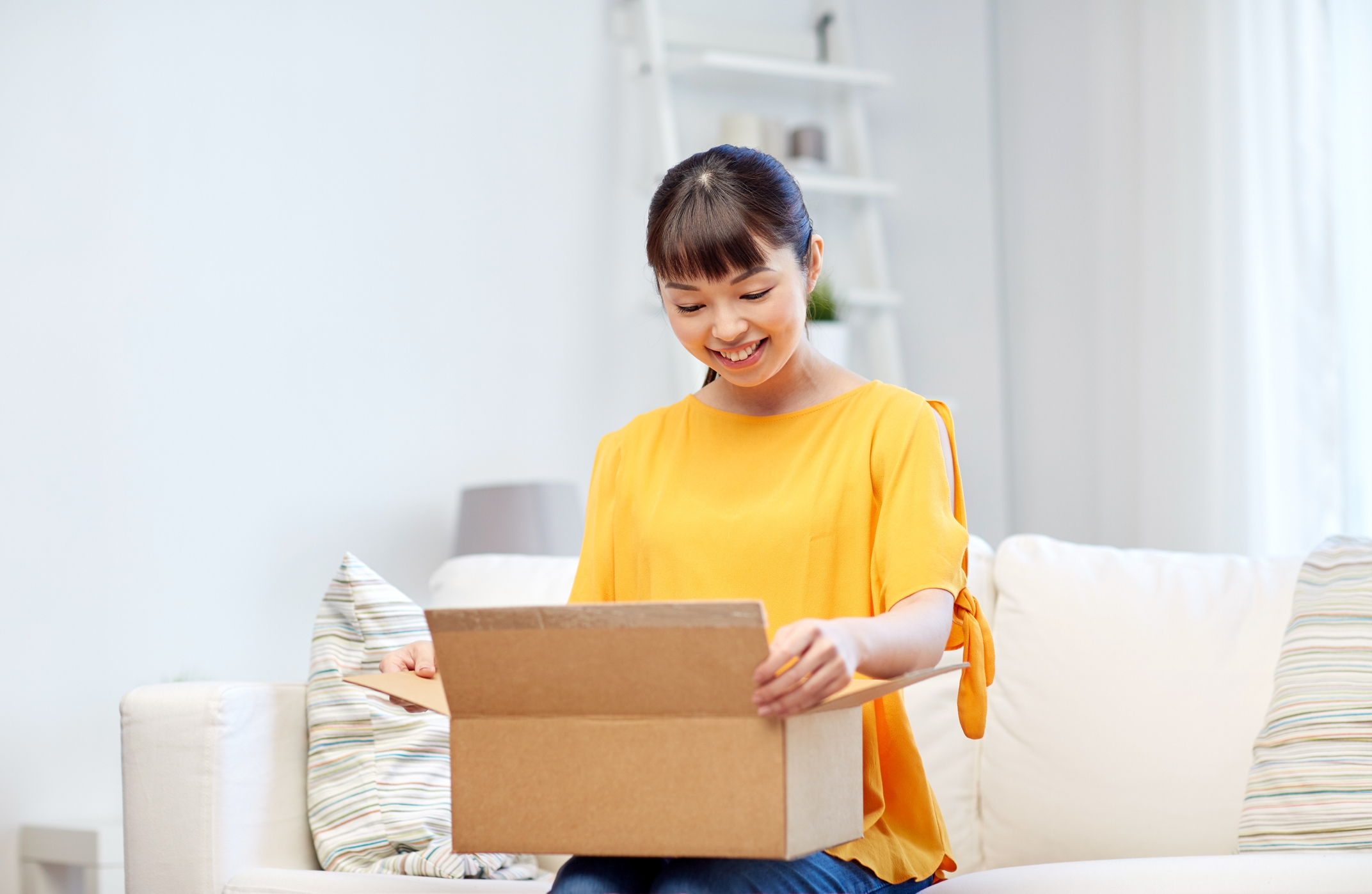 happy asian young woman with parcel box at home