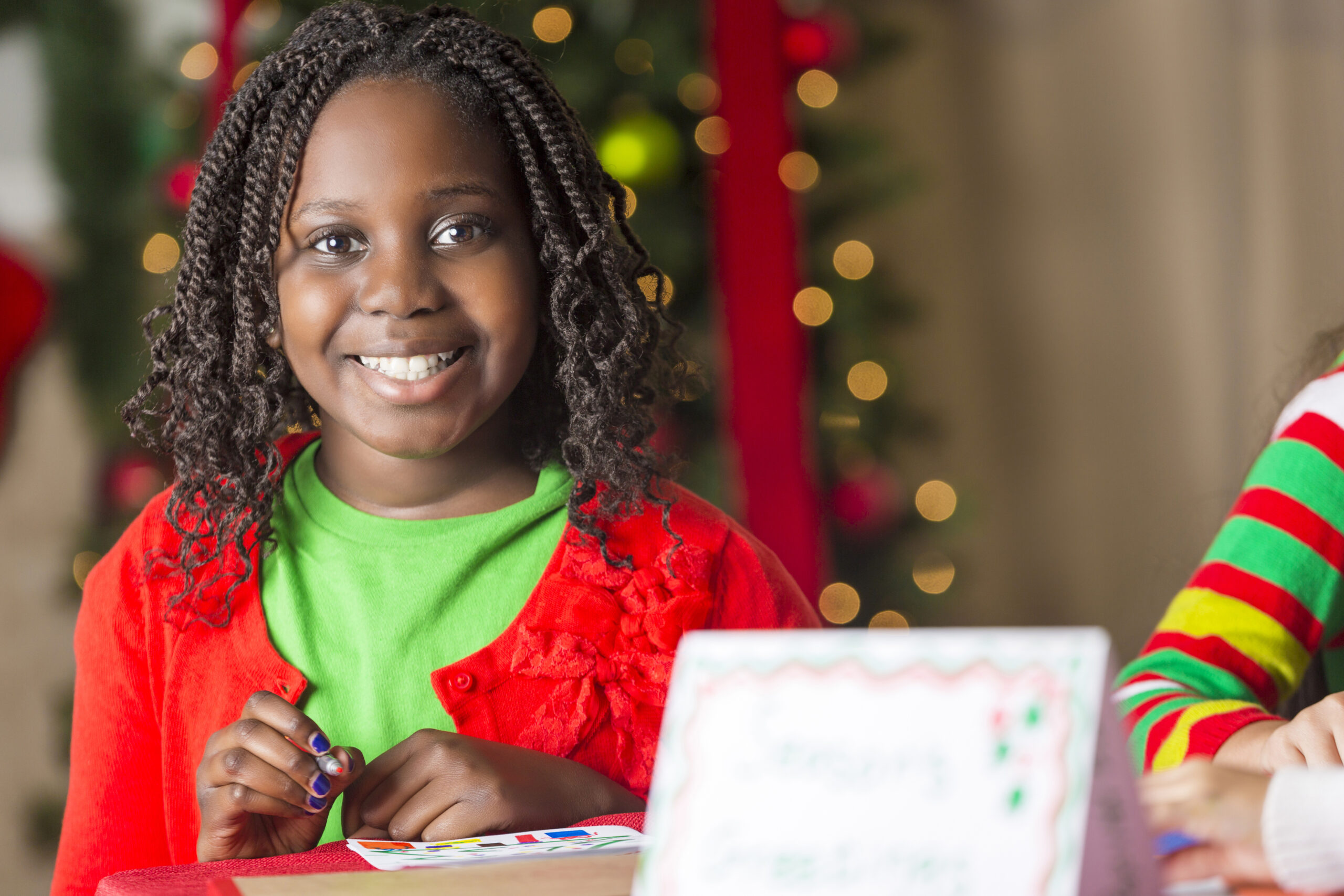 Smiling young girl making Christmas cards