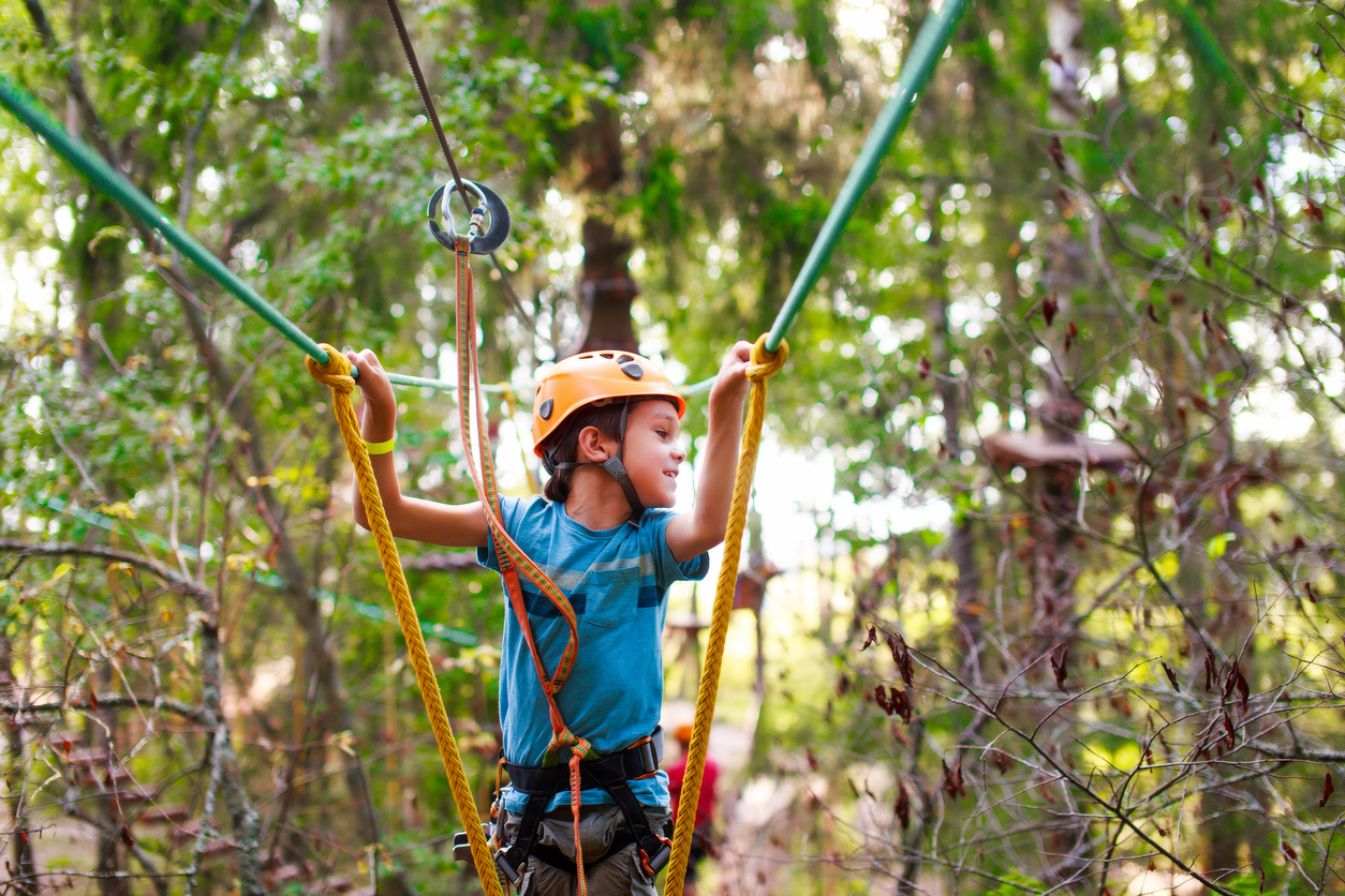 boy passes a rope obstacle course in the forest