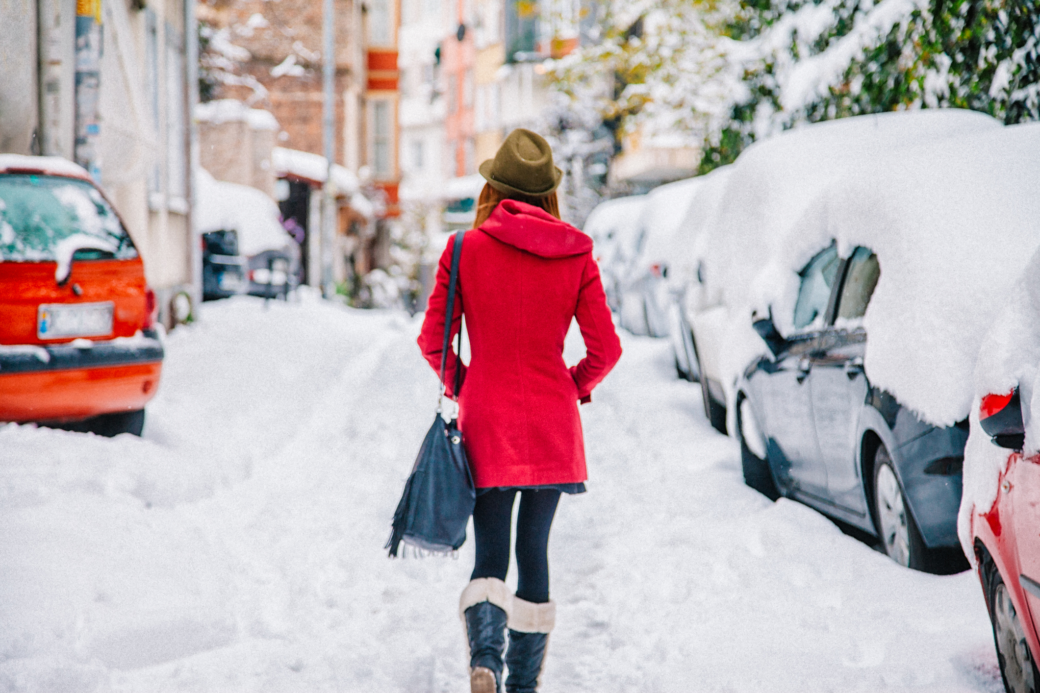 Young woman walking in snow on street