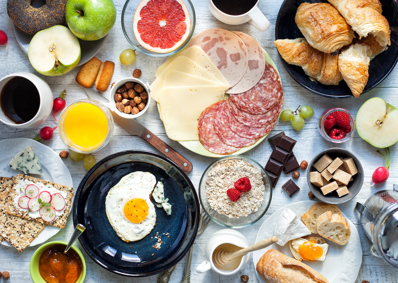 Big breakfast on the white rustic table.
