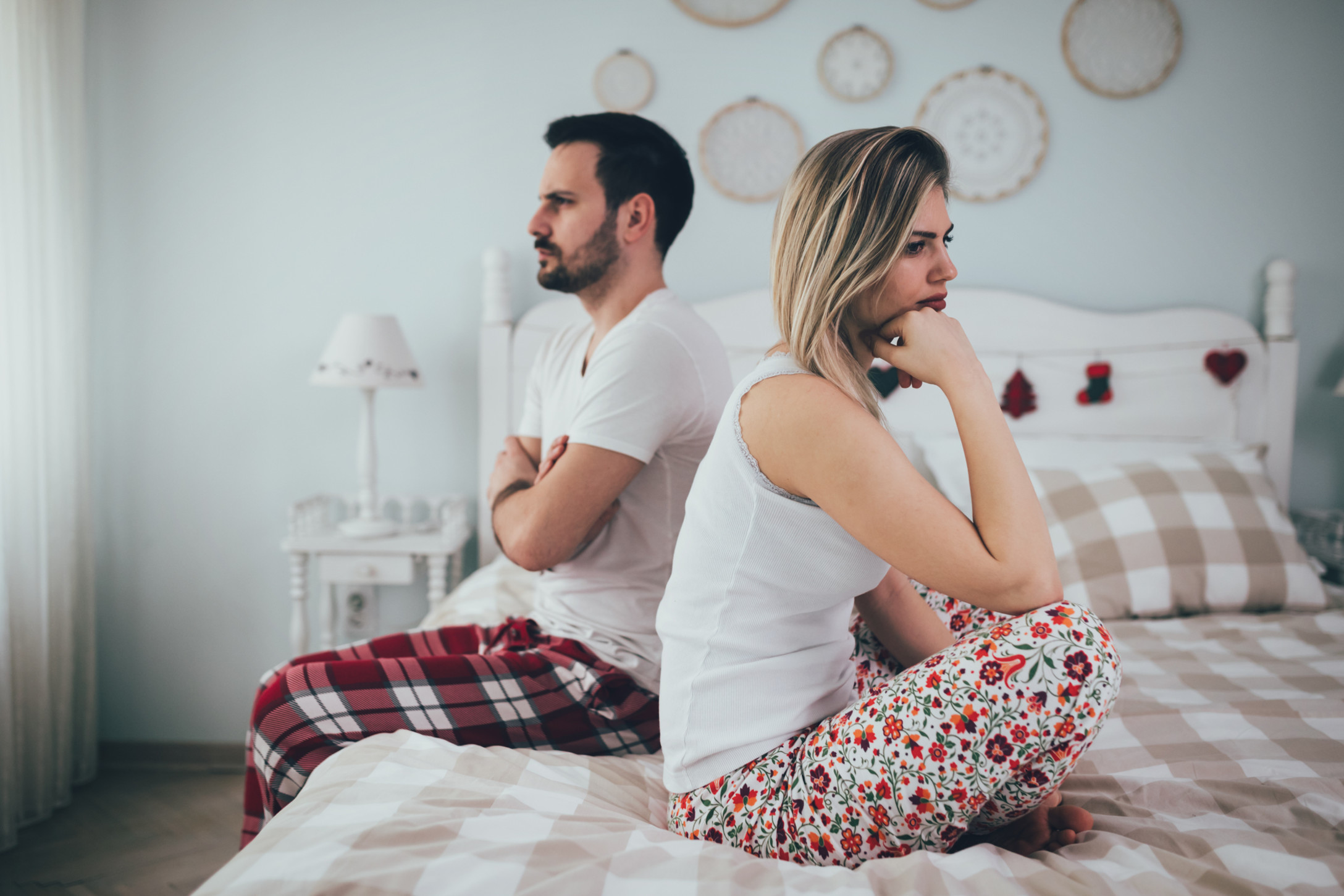 heterosexual couple facing opposite directions on the bed