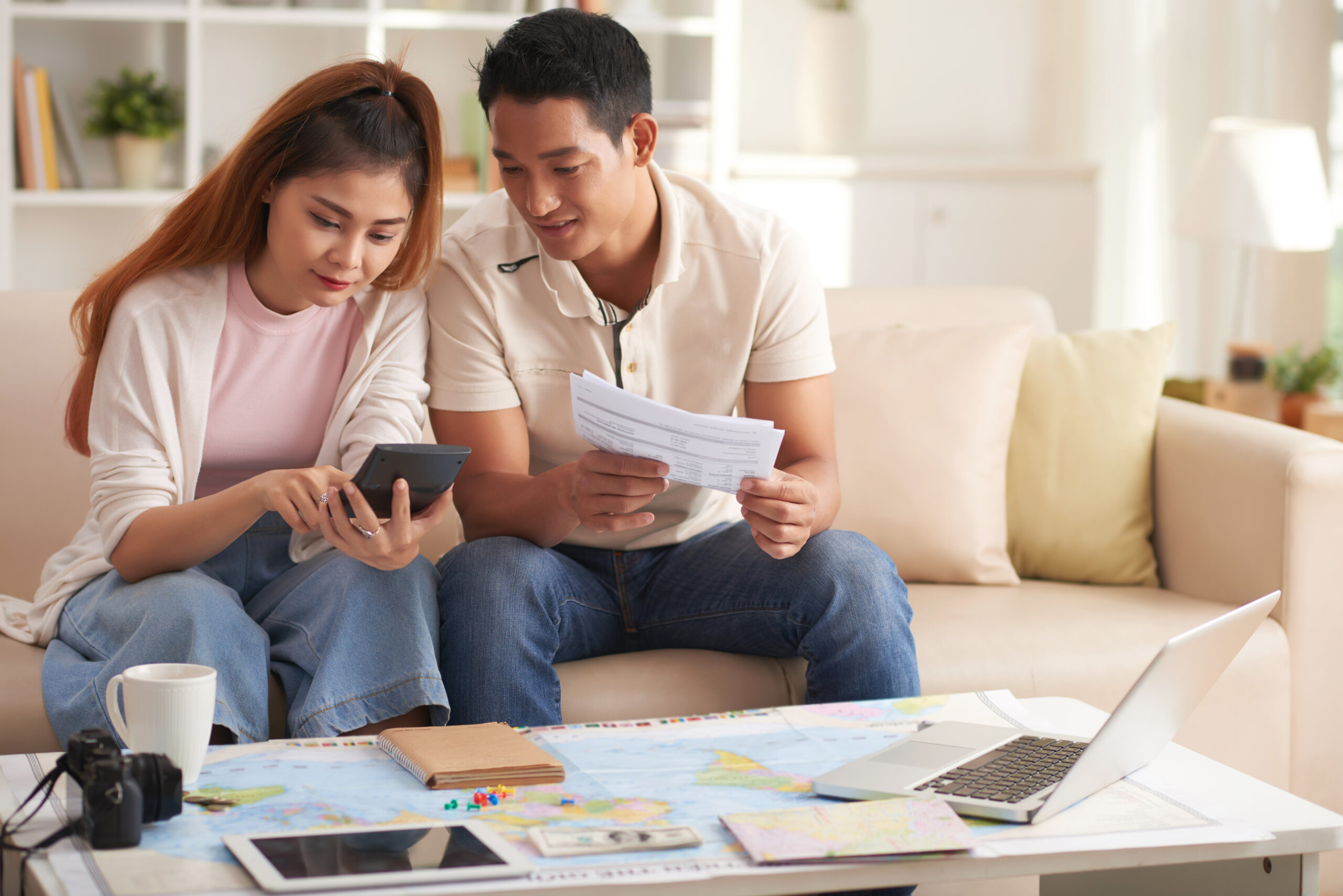 Young Asian Couple Planning Vacation Budget