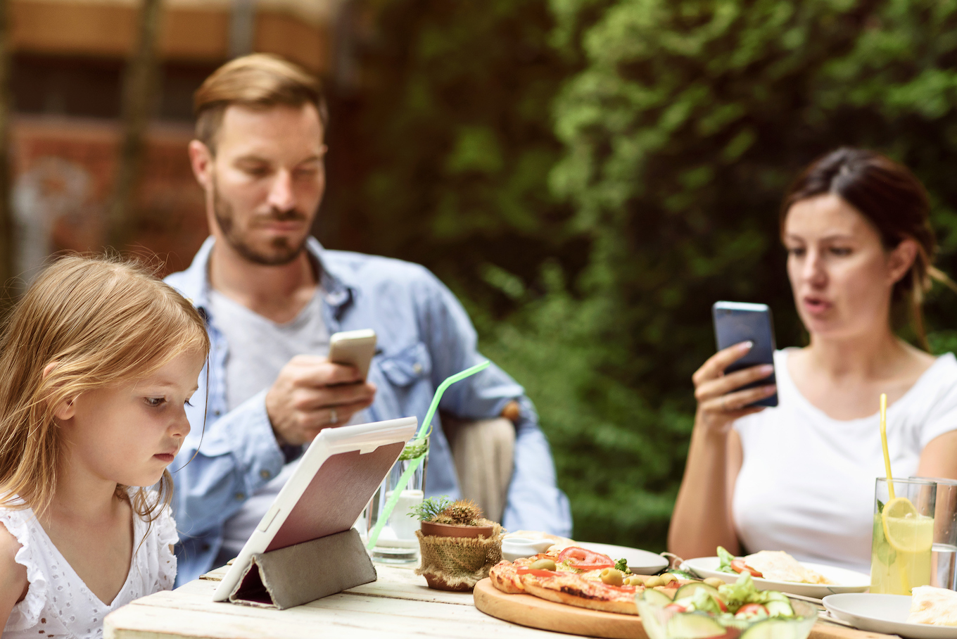 Family using digital technology at a lunch table