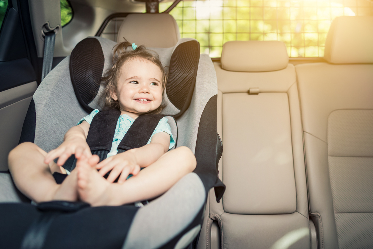 Infant baby girl buckled into her car seat.