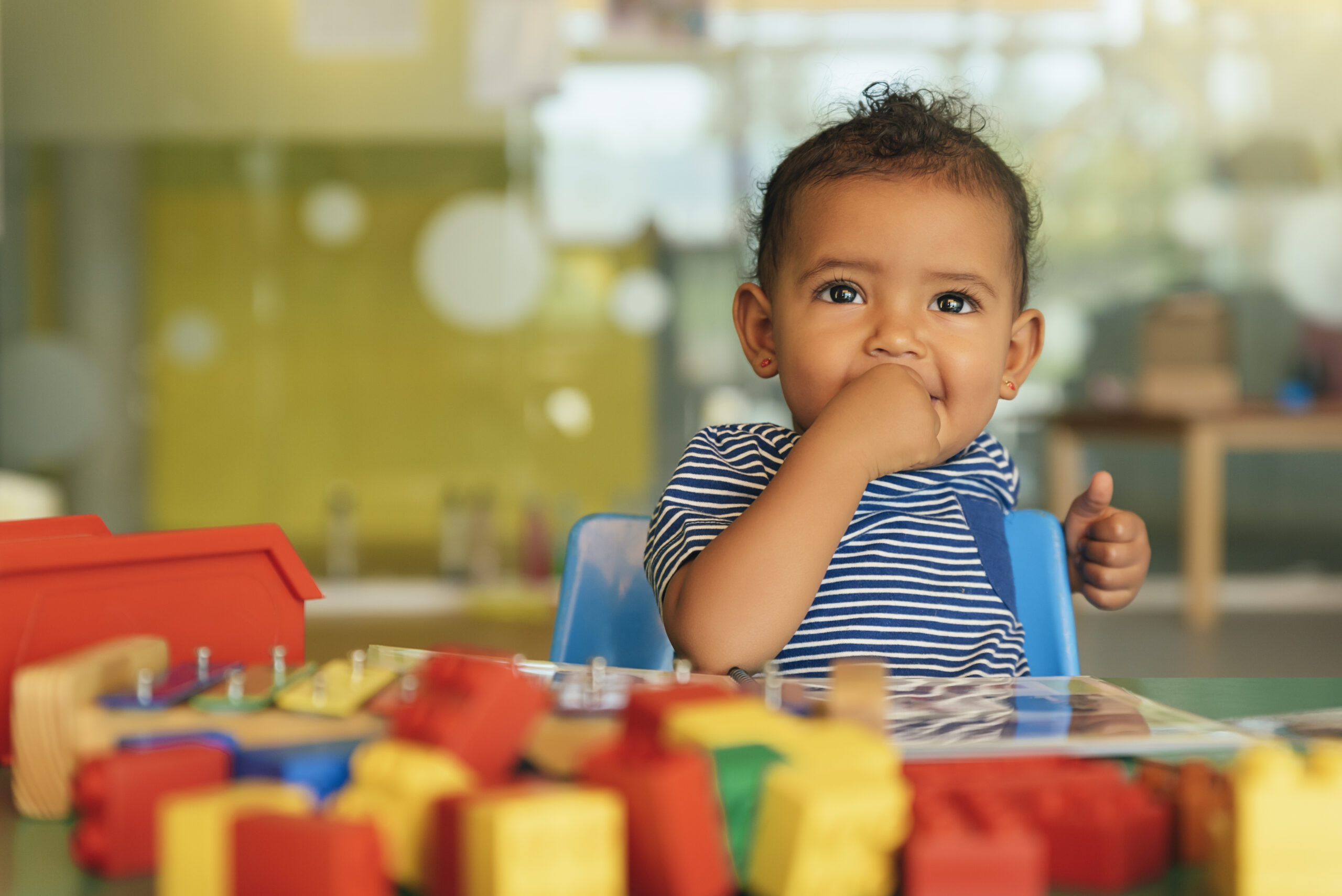 Happy baby playing with toy blocks.