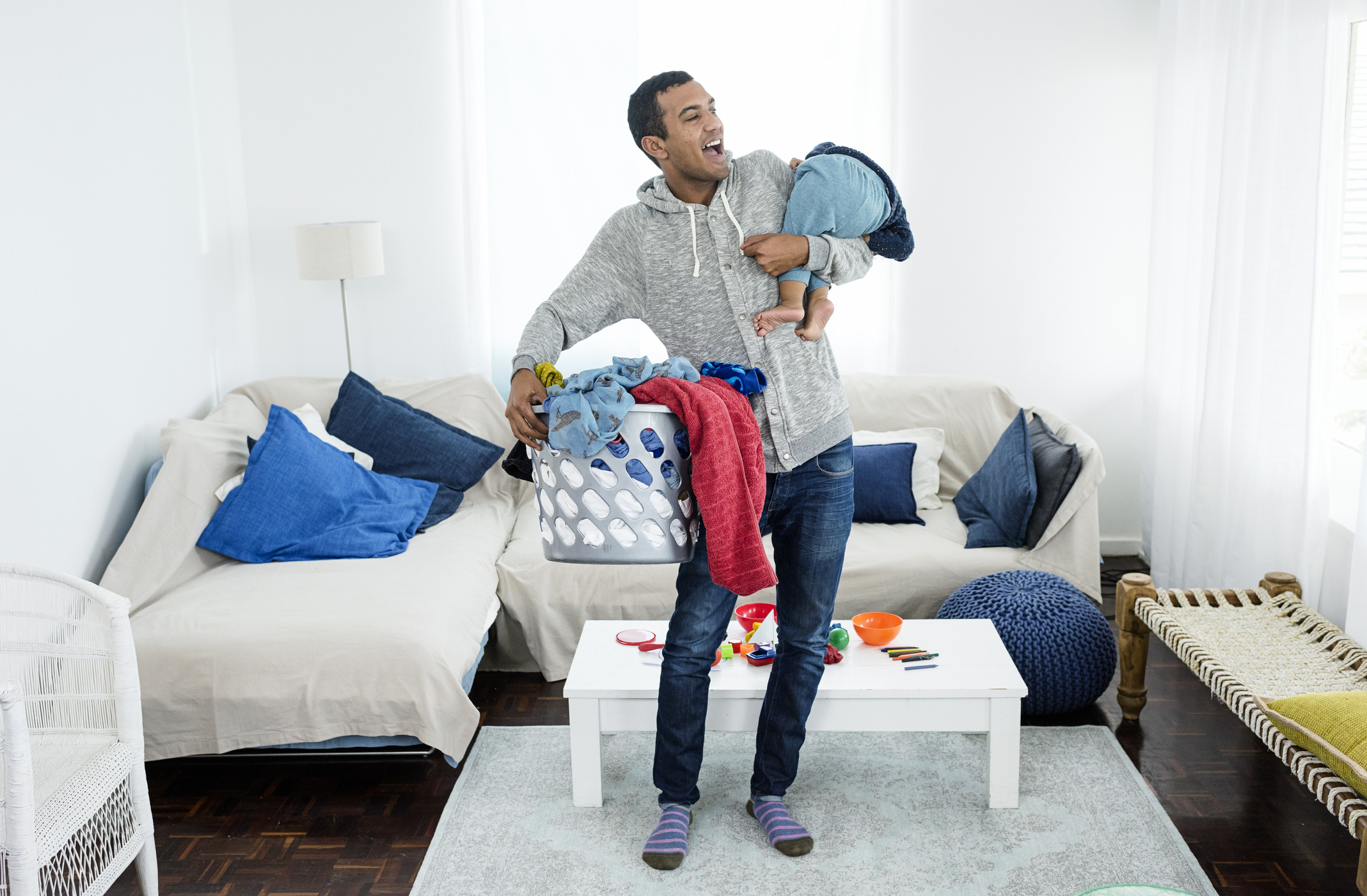 Father picking up laundry and baby
