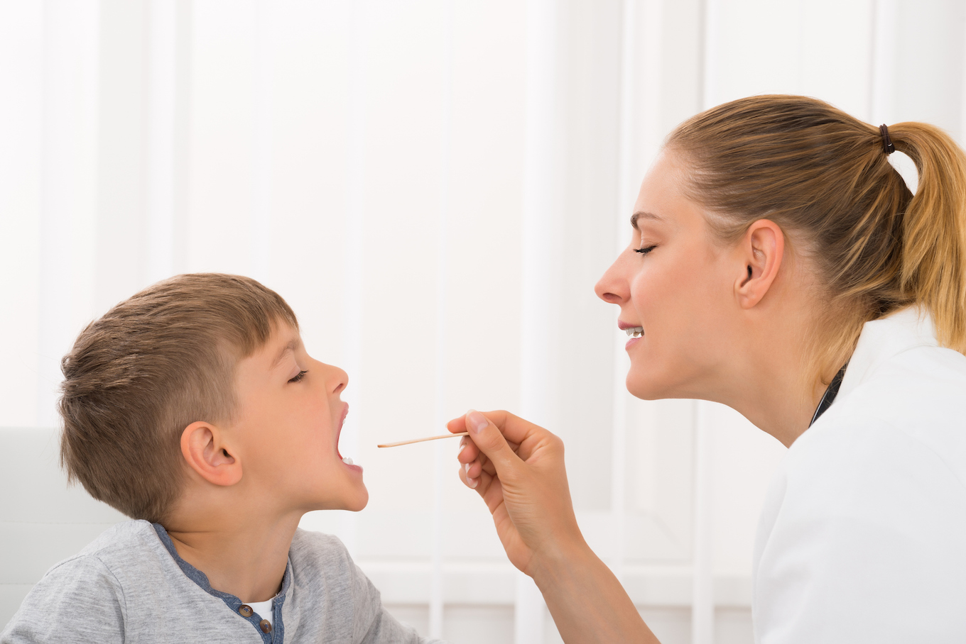 Doctor Examining Boy's Mouth