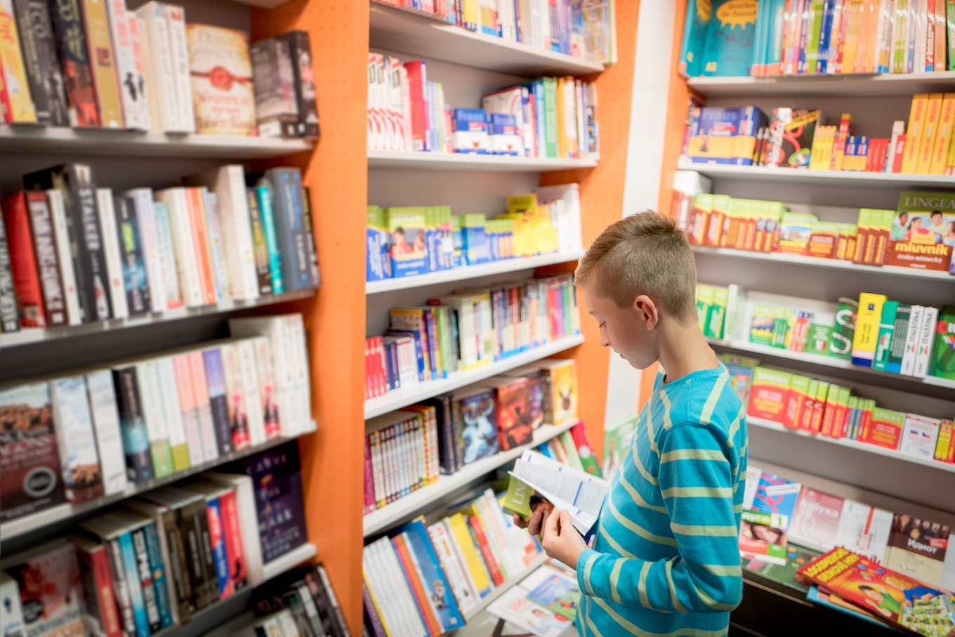 Teenager buying a book in a book store searching content in the book