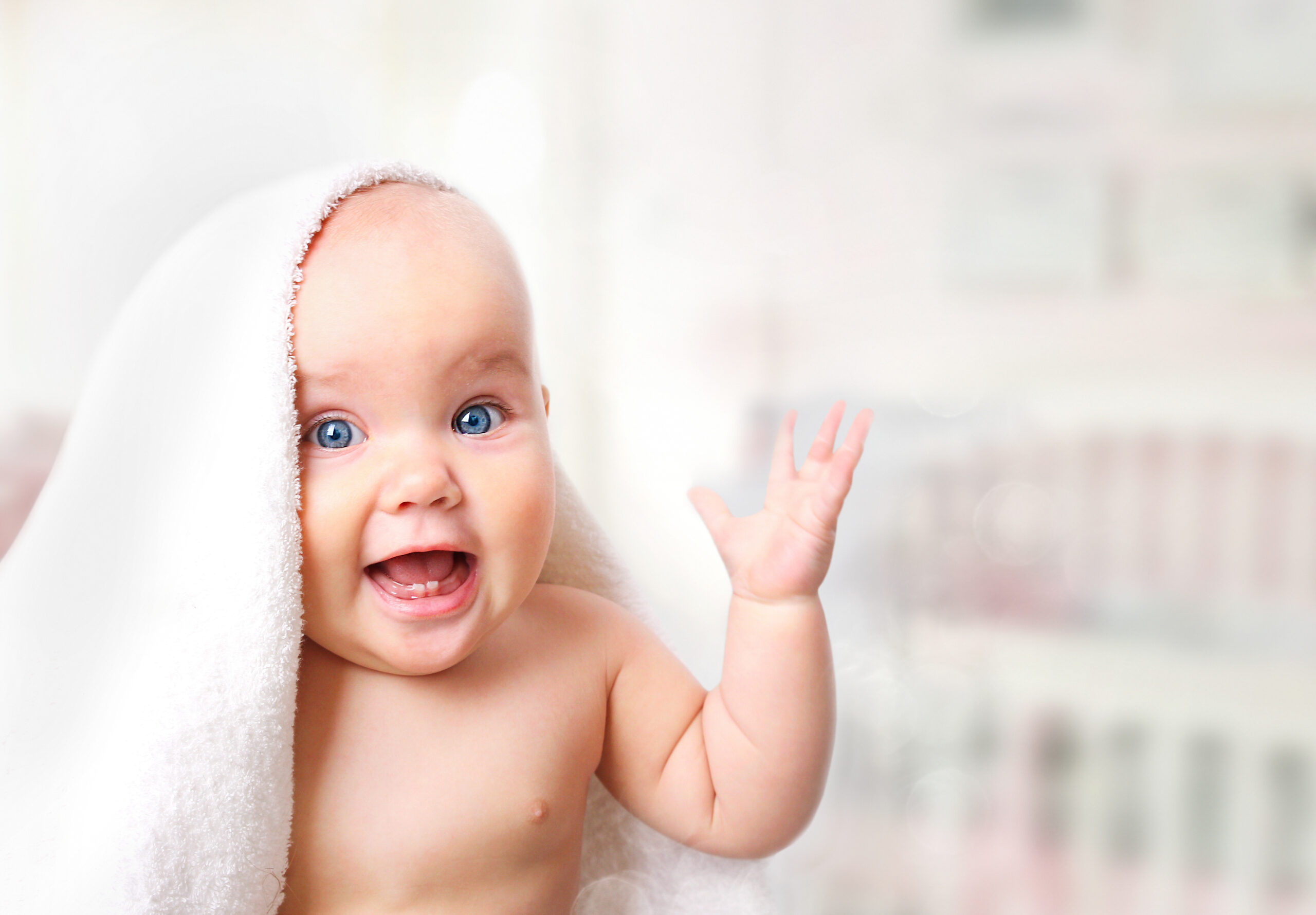 Baby in towel on blur background.