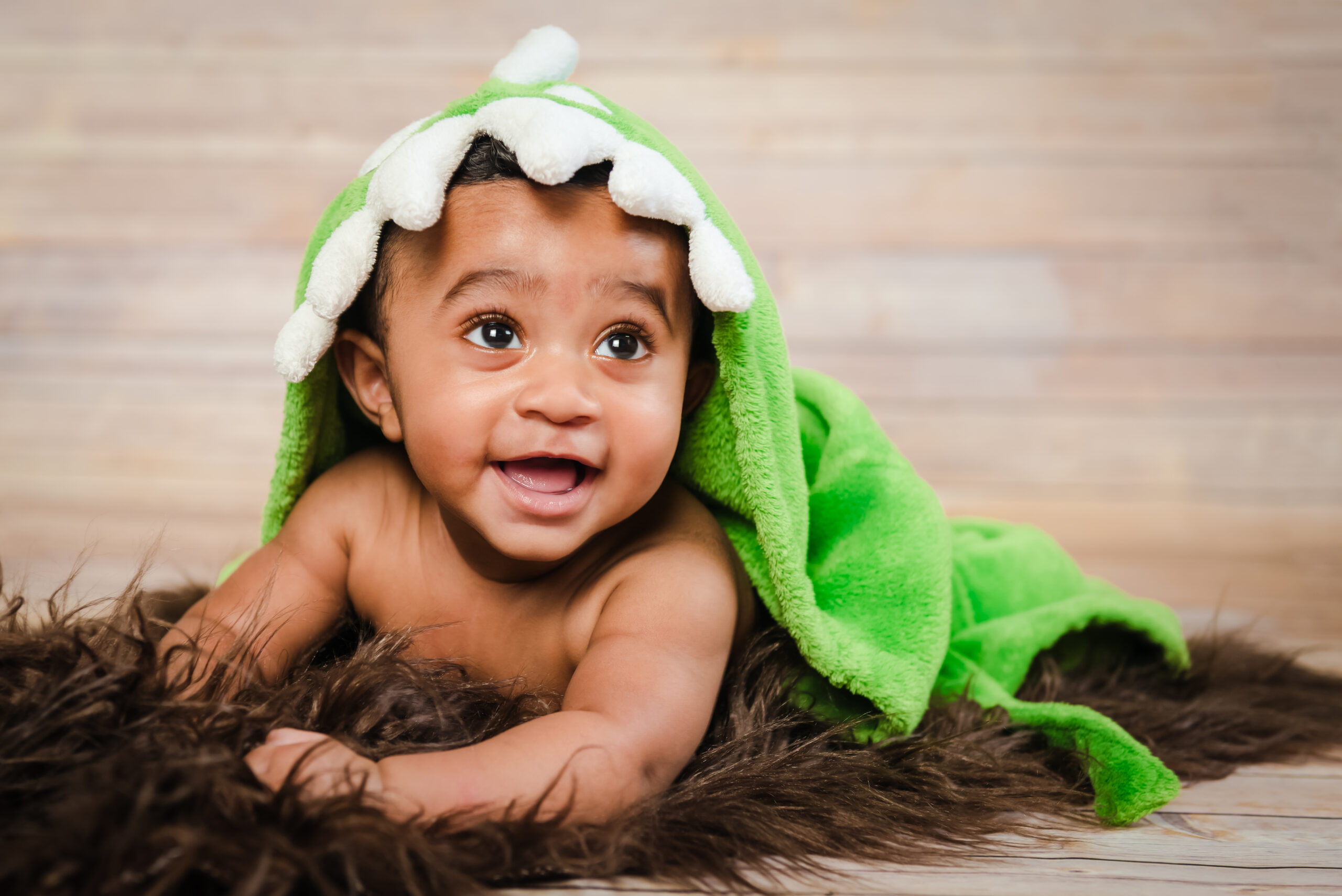 Infant dogla boy wearing bath robe laying on tummy belly