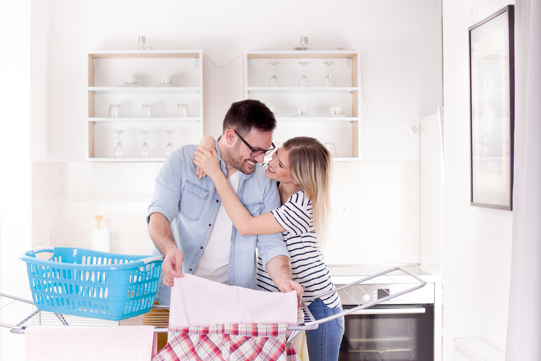 Girl hugging man who doing laundry