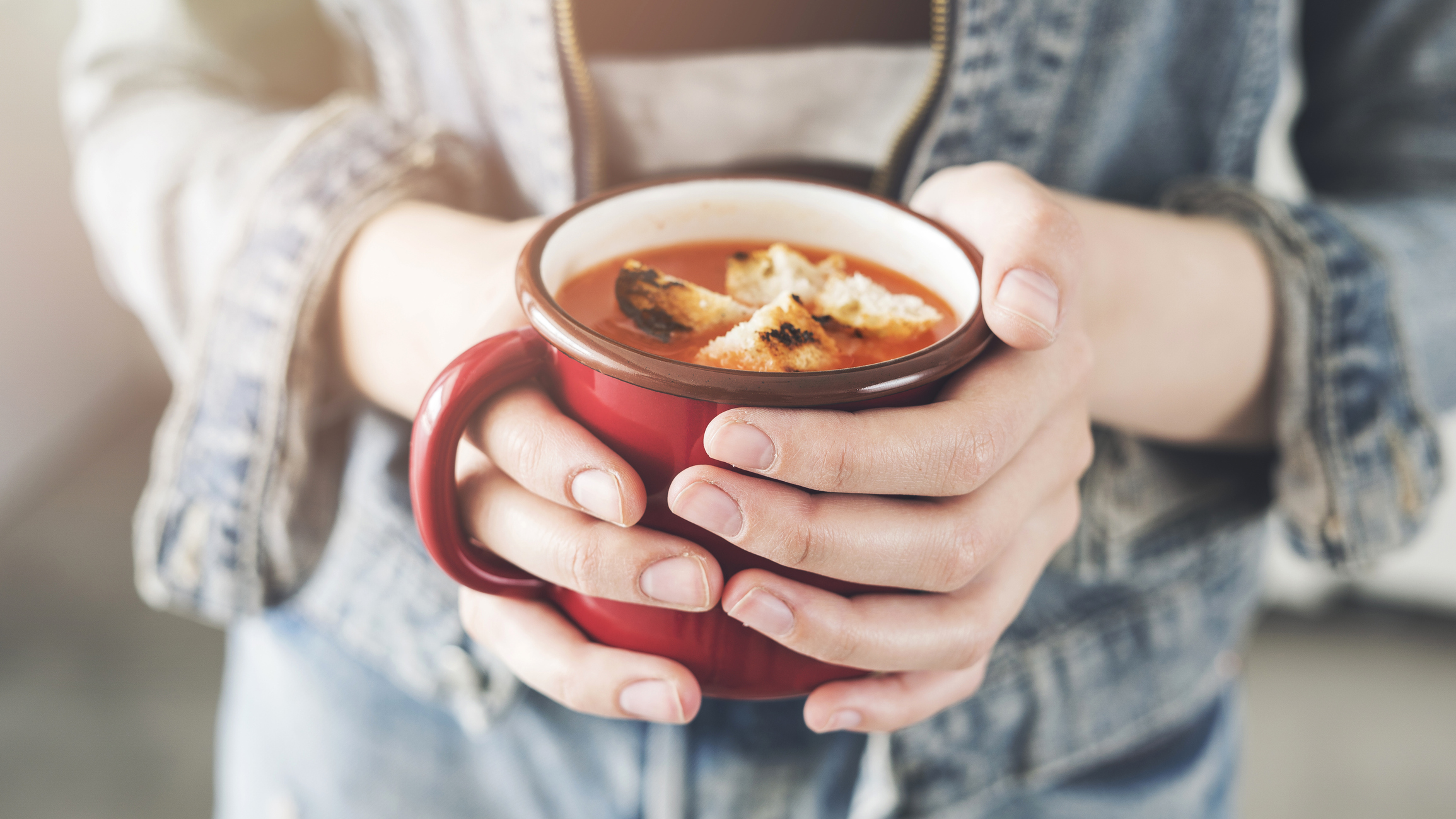 Woman holding tomato soup cup