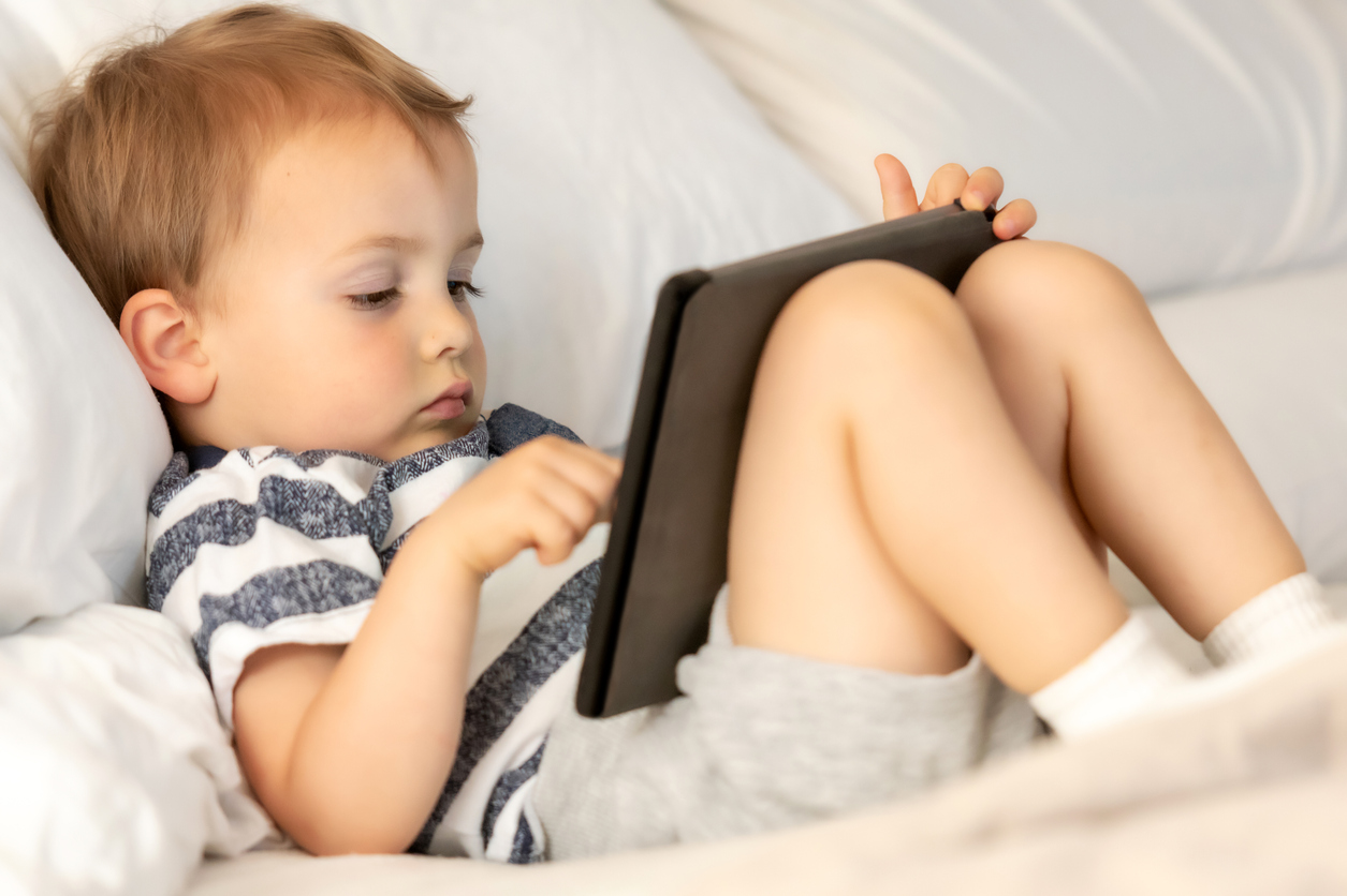 Playing with his electronic tablet