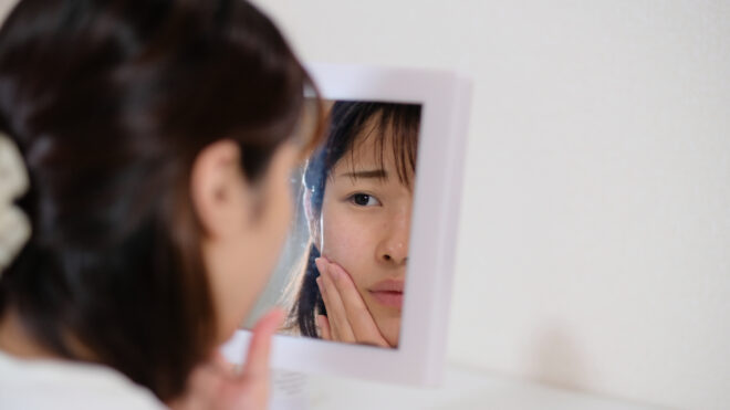 asian woman looking in mirror